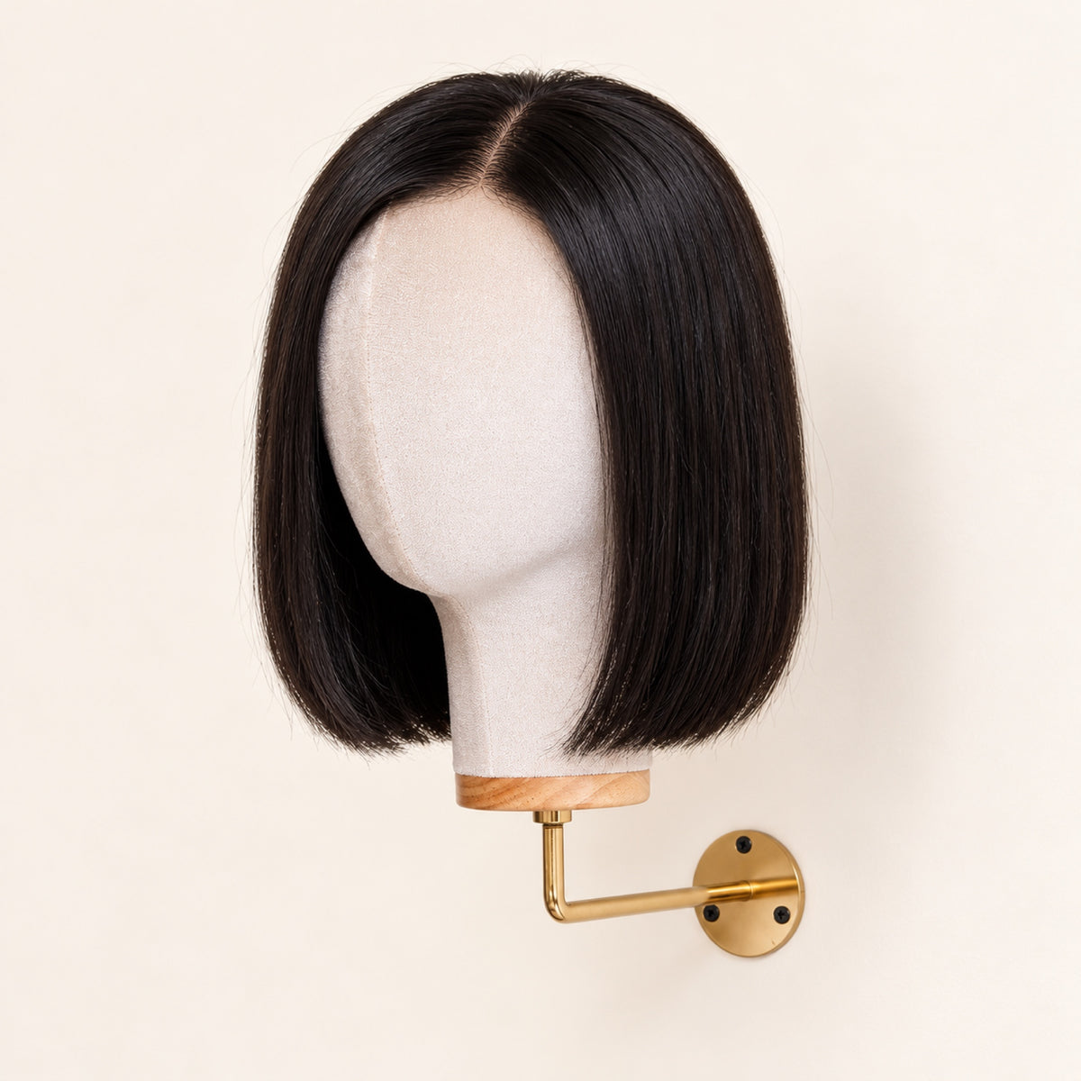 Porte-perruque mural en velours beige à bras doré, avec une perruque carré lisse noire