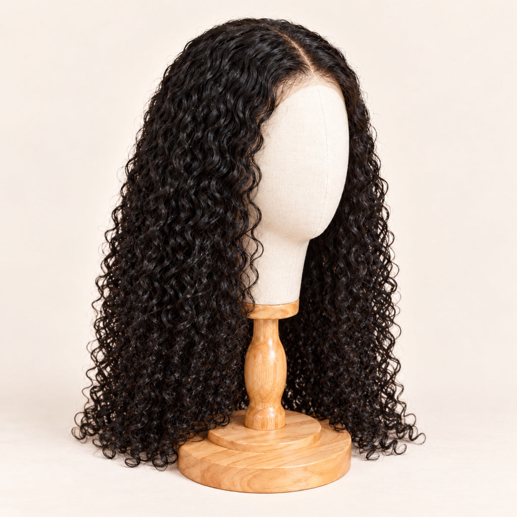 Perruque bouclée noire en cheveux naturels rangée sur une tête en toile à socle en bois