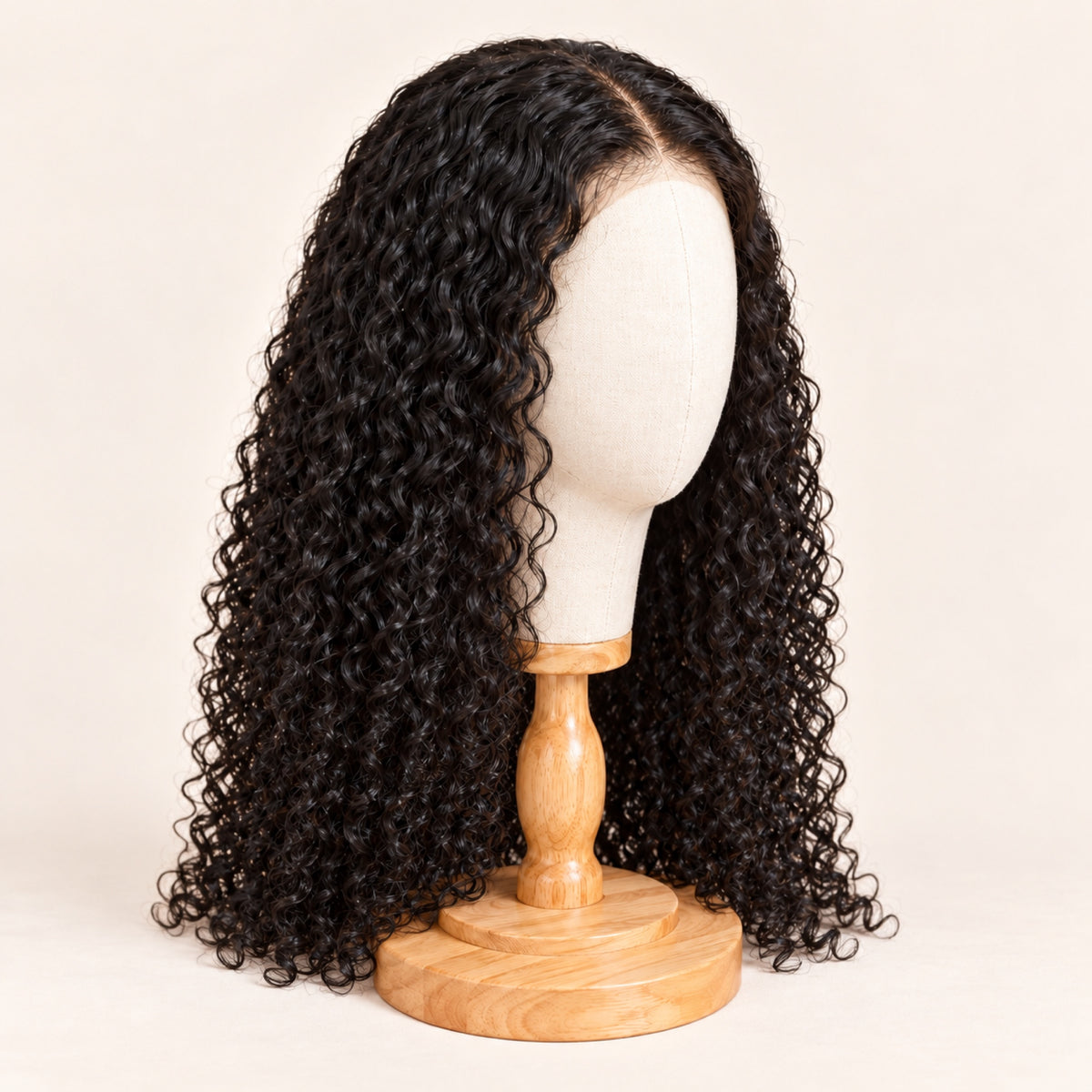 Perruque bouclée noire en cheveux naturels rangée sur une tête en toile à socle en bois